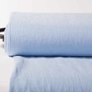 Medium weight pure linen fabric in a solid sky blue color. High quality flax linen is sold by the yard, meter, in bulk on a roll