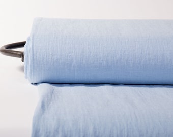 Tissu en lin pur de poids moyen dans une couleur bleu ciel unie. Le lin de haute qualité est vendu au mètre, en vrac sur un rouleau.