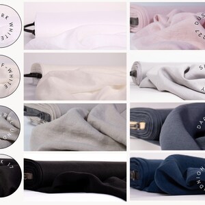 May include: A collection of fabric bolts in various colors including stark white, off-white, natural undyed, black, dusty rose, silver gray, dark gray, and midnight blue. Each fabric swatch is labeled with its color name and a corresponding number.