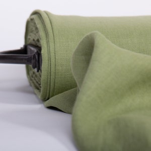 May include: A roll of green fabric with a black metal handle. The fabric is folded and has a soft, textured surface.