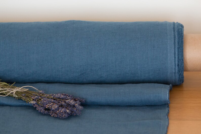 May include: A roll of blue linen fabric with a bundle of dried lavender flowers on top.