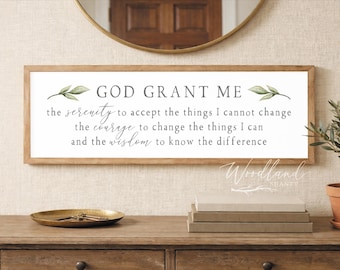 May include: A rectangular wooden framed sign with the text "GOD GRANT ME" and the Serenity Prayer. The sign is above a wooden table with decorative items and a small potted plant. The sign has a white background with green leaf accents.