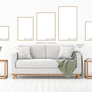 Puede incluir: Cinco marcos de fotos de diferentes tama&ntilde;os en dorado sobre una pared blanca, con un sof&aacute; cama gris claro delante de ellos. Los marcos est&aacute;n etiquetados con sus dimensiones en pulgadas, como 18H x 12W, 30H x 20W, 36H x 24W, 42H x 24W y 24H x 16W. El sof&aacute; cama es un sof&aacute; cama est&aacute;ndar de 72 pulgadas. El texto "WOODLAND SHANTY" es visible en la esquina inferior derecha de la imagen.