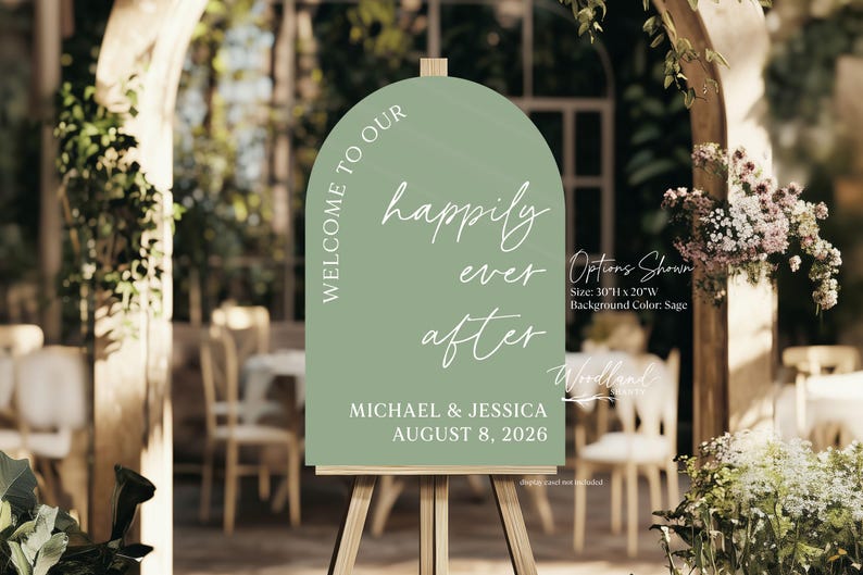 Puede incluir: Un cartel de bienvenida verde salvia con forma de arco y el texto "Welcome to our happily ever after" en blanco. El cartel tambi&eacute;n incluye los nombres "Michael & Jessica" y la fecha "August 8, 2026".