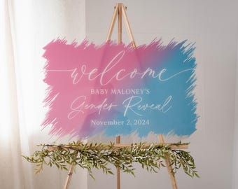 Può includere: Un cartello di benvenuto per una rivelazione di genere rosa e blu con il testo "Welcome Baby Maloney's Gender Reveal November 2, 2024" su uno sfondo acrilico trasparente.
