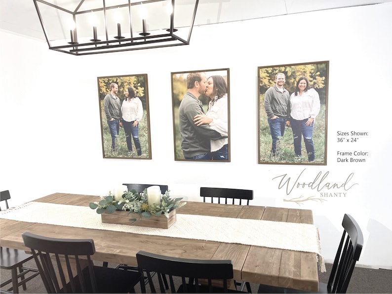 Puede incluir: Tres fotograf&iacute;as enmarcadas de una pareja en un ambiente de comedor. Las fotos miden 91,44 cm por 60,96 cm y tienen marcos de color marr&oacute;n oscuro. La mesa de comedor es de madera y tiene un camino de mesa blanco. Hay sillas negras alrededor de la mesa y una caja de madera con vegetaci&oacute;n y velas en el centro.