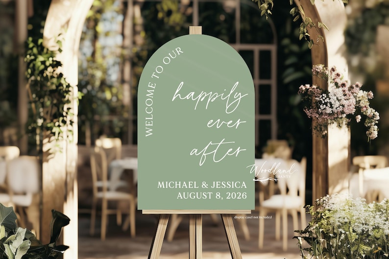 Puede incluir: Un cartel de bienvenida de boda de color verde en forma de arco con texto blanco que dice "Bienvenido a nuestro felices para siempre Michael & Jessica 8 de agosto de 2026".