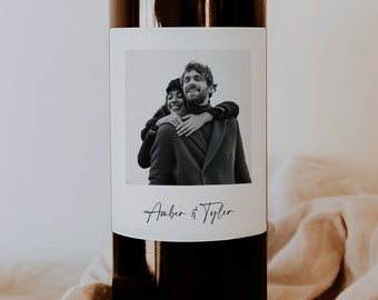 May include: A black and white photograph of a couple on a wine bottle label. The label has a white border and the text "Amber & Tyler" at the bottom.