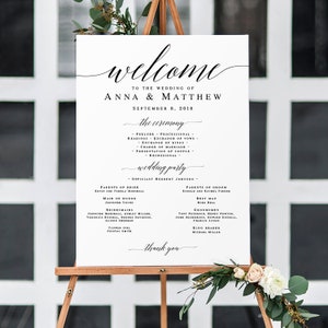 May include: A white wedding welcome sign on a wooden easel. The sign features elegant calligraphy with the words "welcome" and "Anna & Matthew." It lists the ceremony details, wedding party, and date, September 8, 2018. Floral accents adorn the easel.