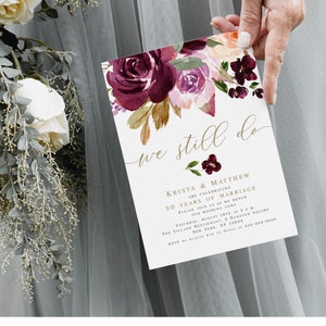 Puede incluir: Una invitación de boda blanca con un diseño floral de acuarela en color burdeos y melocotón. La invitación dice "we still do" y anuncia que Krista & Matthew celebran 30 años de matrimonio. La invitación incluye la fecha, la hora y el lugar del evento.