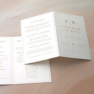 May include: Wedding invitation suite with a tri-fold design. The invitation is white with gold text, featuring the names "Elizabeth and Kevin" and wedding details. The design includes sections for the ceremony, reception, and special thanks.