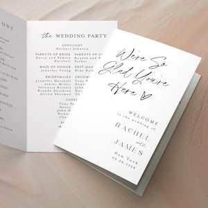 May include: A set of white wedding programs with black text. The programs are open, displaying the ceremony details, wedding party, and a welcome message. The programs are on a light-colored surface.