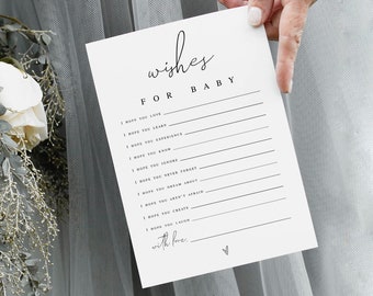 Puede incluir: Una tarjeta blanca con texto negro que dice "wishes for baby" e incluye una lista de deseos para un bebé. La tarjeta está sostenida por una mano frente a un fondo floral blanco y gris.