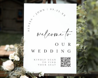 May include: White wedding welcome sign with black text. The sign reads "Alyssa + John | 09.25.XX" and "Welcome to our wedding".  It also includes a QR code with the text "Kindly scan to find your seat".