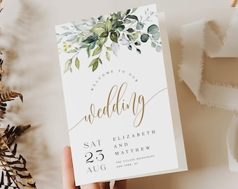 May include: A white wedding invitation with a watercolor illustration of green leaves and flowers. The text reads "Welcome to our wedding" in gold script. The date is listed as "Sat 23 Aug" and the names "Elizabeth and Matthew" are listed below. The venue is listed as "The Village Restaurant, New York, NY."