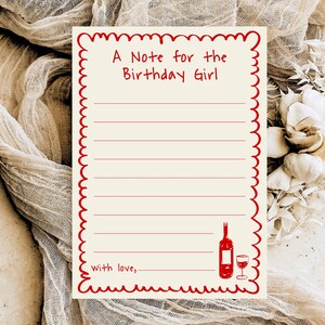 May include: A cream-coloured birthday card with a red scalloped border. The card reads "A Note for the Birthday Girl" and features a wine bottle and glass illustration. The card is lined for writing and says "with love,".