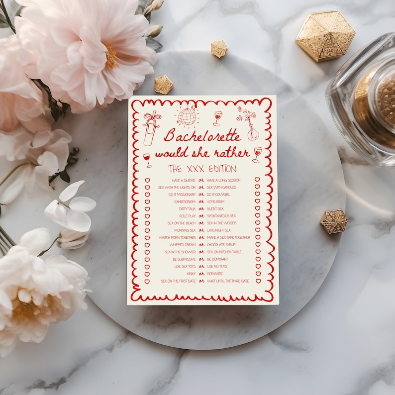 May include: A white card with red text and a decorative border. The card reads "Bachelorette would she rather THE XXX EDITION" with a list of playful questions. The card is surrounded by flowers and decorative items.