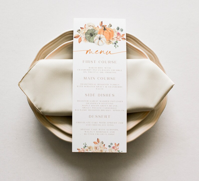 Op de afbeelding: Een Thanksgiving-menu met een aquarelillustratie van pompoenen en herfstbladeren. Het menu bevat een voorgerecht, een hoofdgerecht, bijgerechten en een dessert. De tekst luidt: "menu", "Eerste gang", "Gebakken brie met cranberry-pecan-bacon-kruimels op truffelolie-crostini", "Hoofdgerecht", "Traditionele geroosterde kalkoen met jus en cranberry-saus", "Bijgerechten", "Geroosterde knoflookpuree", "Oma's vulling", "Esdoorn-bacon-groene bonen", "Zoete aardappel-schotel", "Balsamico-geroosterde spruitjes", "Dessert", "Chocoladetaart met abrikozenjam en chocolade-glazuur", "Biscuit met amandelen, walnoot-meringue en klassieke roomboter"