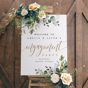 Puede incluir: Un cartel blanco con acentos florales de acuarela verde y gris que anuncia una fiesta de compromiso para Amelia y Jacob. El cartel dice "Bienvenido a Amelia & Jacob's Engagement Party 08.20.20XX Chicago, Illinois".