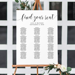 May include: A white wedding seating chart with black text. The chart is titled "find your seat" with the names Anna & Matthew and the date September 8, 2018. The chart lists tables 1 through 15 with guest names.