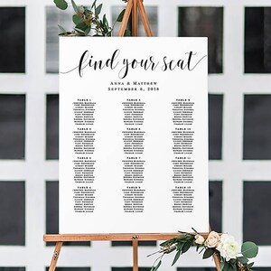 May include: A white wedding seating chart with black text. The chart is titled "find your seat" with the names Anna & Matthew and the date September 8, 2018. The chart lists tables 1 through 15 with guest names.