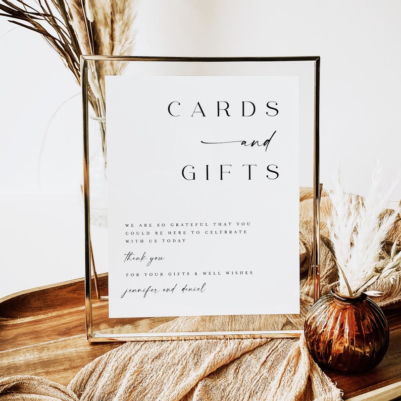 May include: A gold-framed sign with the text "CARDS and GIFTS" and a message thanking guests for their gifts and well wishes for Jennifer and Dincel.