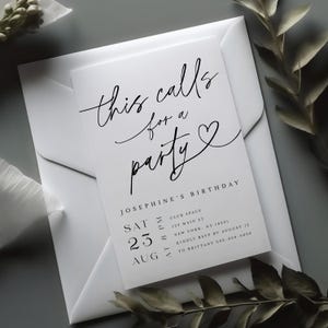 May include: A white invitation card with black script that reads "this calls for a party" and details for Josephine's birthday. The card is inside a white envelope, with a sprig of greenery in the background.
