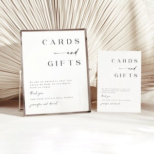 May include: Two white signs with black text that read "CARDS and GIFTS". The signs are on a stand and have a message thanking guests for their gifts and well wishes.
