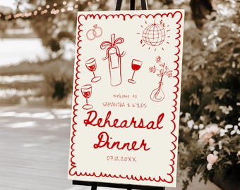May include: A cream-coloured sign with red illustrations and text, displayed on a black easel. The sign features drawings of rings, wine glasses, a bottle, and a disco ball. The text reads "Welcome to SAMANTHA & KYLES Rehearsal Dinner 07.12.20XX".