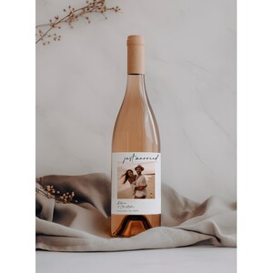 May include: A bottle of rose wine with a personalized label that says "just married" with a photo of a couple on a beach and the text "Blake & Christopher September 12, 2022".