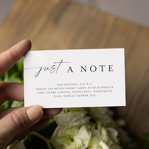 Pode incluir: Um cartão retangular branco com o texto "just A NOTE" em estilo manuscrito. O cartão também inclui texto adicional sobre suas características. O cartão é segurado em uma mão, com uma superfície de madeira e flores no fundo.