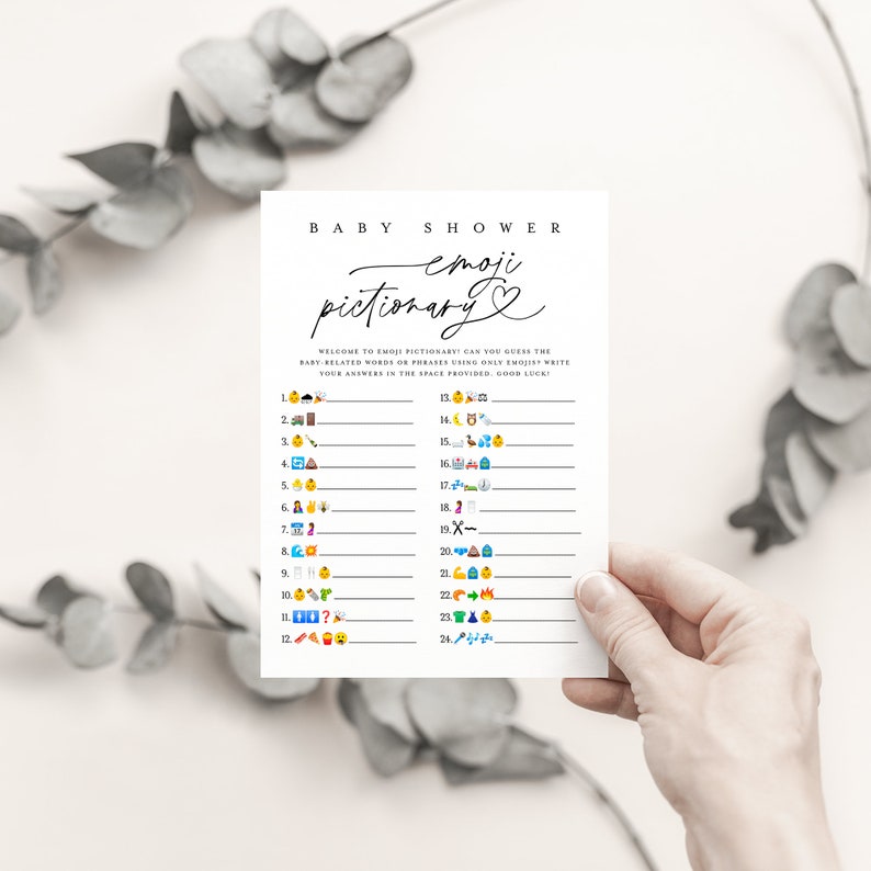 May include: A printable baby shower game called "Emoji Pictionary". The game features 24 emoji icons and blank lines for players to write down their guesses. The text on the card reads "Baby Shower Emoji Pictionary".