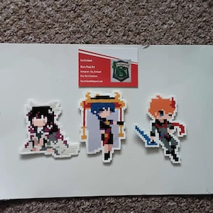May include: Three pixel art figures made with colourful beads. The figures are of anime characters. The figure on the left is a female character with long black hair and a white and purple outfit. The figure in the middle is a female character with blue hair and a blue and red outfit. The figure on the right is a male character with orange hair and a blue and red outfit. The figures are on a white background. A business card with the text "Kia Kirkland Kia's Pixel Art Instagram: Kia_Kirkland Etsy: Kia's Kreations Kia.kirkland@gmail.com" is in the top right corner of the image.