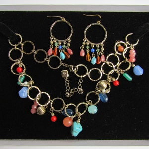 May include: A gold chain necklace with a variety of colorful beads, including turquoise, coral, and blue, and a matching pair of gold hoop earrings with dangling beads.