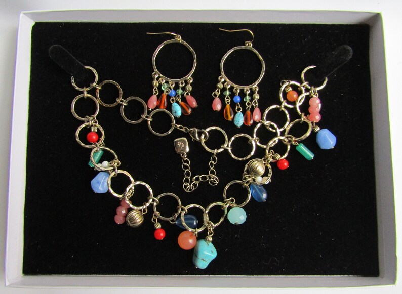 May include: A gold chain necklace with a variety of colorful beads, including turquoise, coral, and blue, and a matching pair of gold hoop earrings with dangling beads.