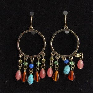 May include: Gold hoop earrings with dangling beads in shades of turquoise, green, brown, and pink.