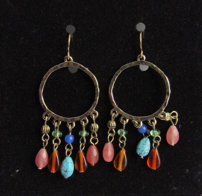 May include: Gold hoop earrings with dangling beads in shades of turquoise, green, brown, and pink.