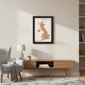 May include: A framed wooden map of the UK, featuring detailed city and regional markings. The map is set against a beige backdrop and enclosed in a black frame. The text "Olivia's Travel Map" is at the top, ideal for travel enthusiasts.