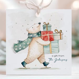May include: A square gift tag featuring a watercolor illustration of a polar bear wearing a scarf and ice skates, carrying wrapped presents. The tag includes the text "a gift from The Johnsons". The tag is tied with a string.