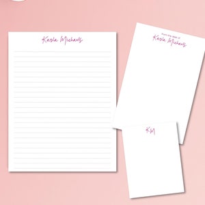May include: White stationery set with lined notepad, blank notepad, and small note card. The name "Kayla Michaels" is printed in a magenta script on the notepad and note card. The words "from the desk of" are above the name on the blank notepad.