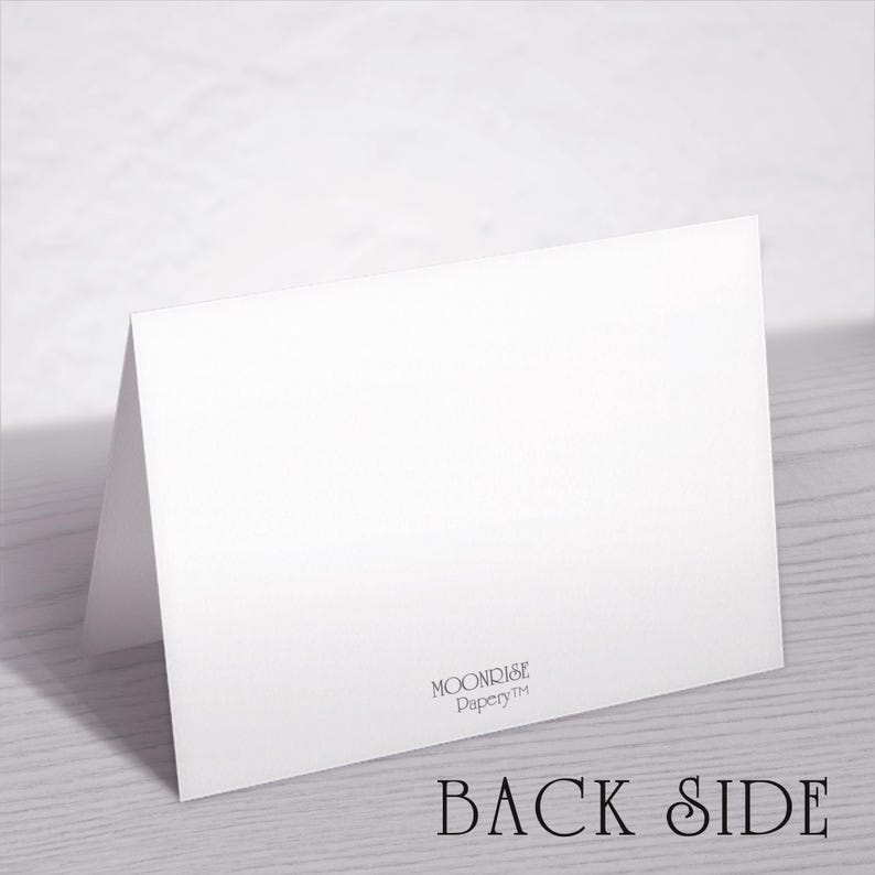 May include: A white folded card with the text "BACK SIDE" in a serif font. The card is angled, revealing the back and a portion of the front. The Moonrise Papery&trade; logo is visible.