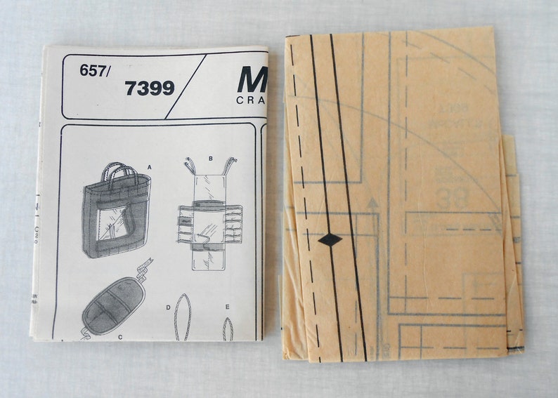 May include: A sewing pattern for a tote bag with a zippered pocket. The pattern is labeled "657/7399" and is from McCall's Crafts.