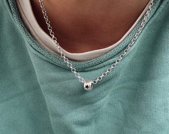Könnte beinhalten: Eine silberne Kettenkette mit einem kleinen sternförmigen Anhänger.