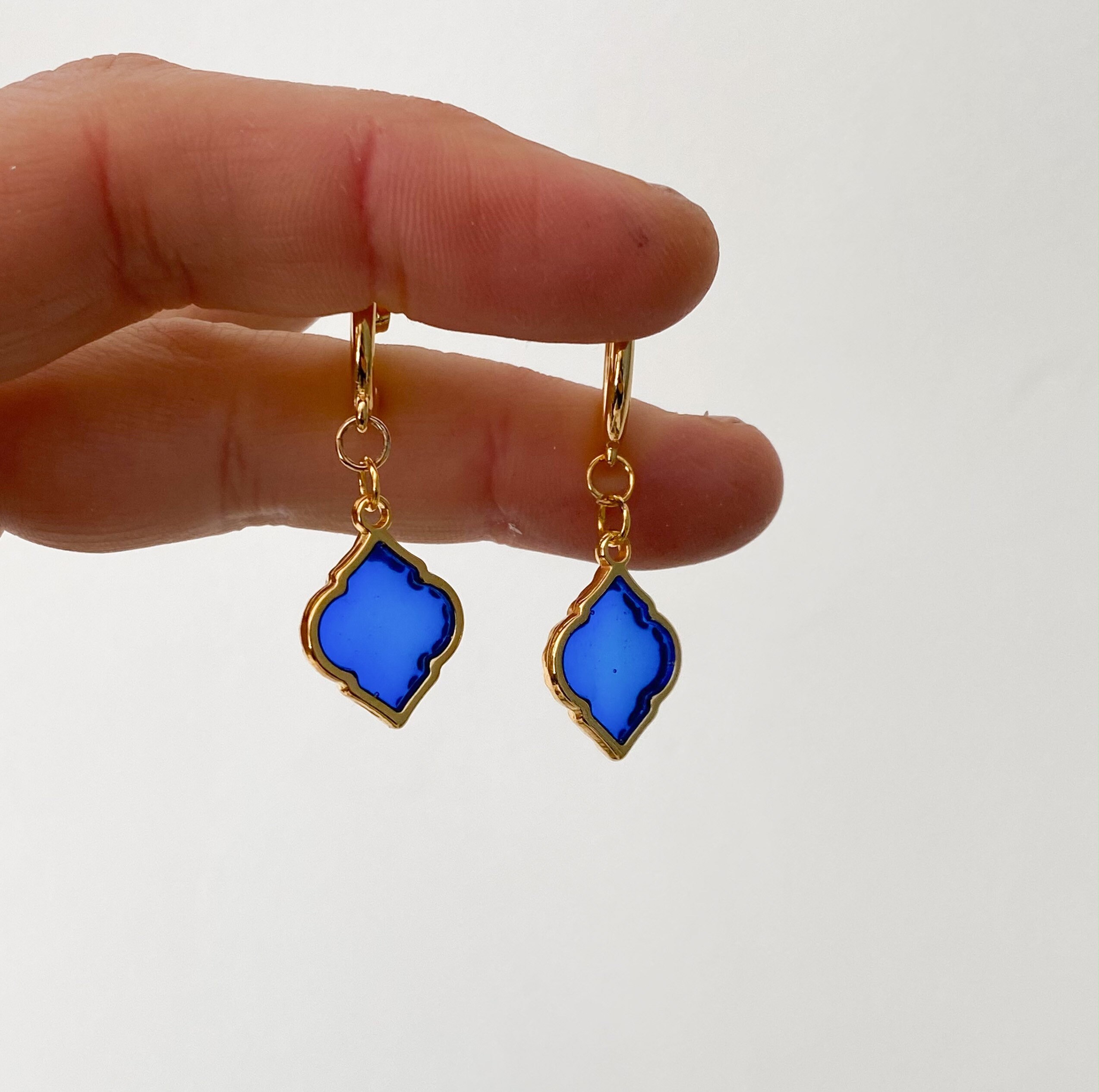Blue glass earring with gold colored metal accents and hook