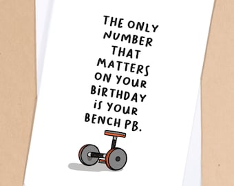 Könnte beinhalten: Eine weiße Karte mit schwarzem Text, der lautet: "Die einzige Zahl, die an deinem Geburtstag zählt, ist dein Bankdrücken-PB." Unter dem Text befindet sich eine Schwarzweißillustration einer Hantelbank mit orangenen Gewichten.