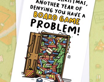 May include: A humorous Christmas card with the text "ANOTHER CHRISTMAS, ANOTHER YEAR OF DENYING YOU HAVE A BOARD GAME PROBLEM!". The illustration shows a door overflowing with board games, a Christmas tree, and a gift.