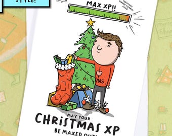 May include: A Christmas greeting card with a cartoon illustration. The card features a person decorating a Christmas tree, a stocking, and gifts. Text reads "May your Christmas XP be maxed out!" and "MAX XP!!".