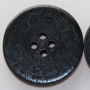 May include: Black wooden button with four holes and the word "GUCCI" embossed around the edge.