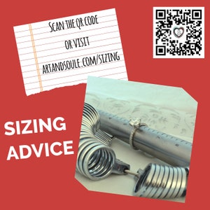 Op de afbeelding: Een close-up van een ringmaat met een zilveren ring met een diamant. De ringmaat heeft een liniaal met nummers van 4 tot 8. De tekst "SCAN THE QR CODE OR VISIT ARTANDSOUL.COM/SIZING" staat op een papiertje.