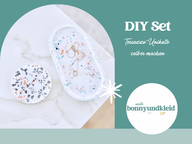 May include: A white terrazzo jewelry tray and coaster set with colorful flecks. A gold necklace rests on the oval tray. The image includes the text "DIY Set" and a logo.
